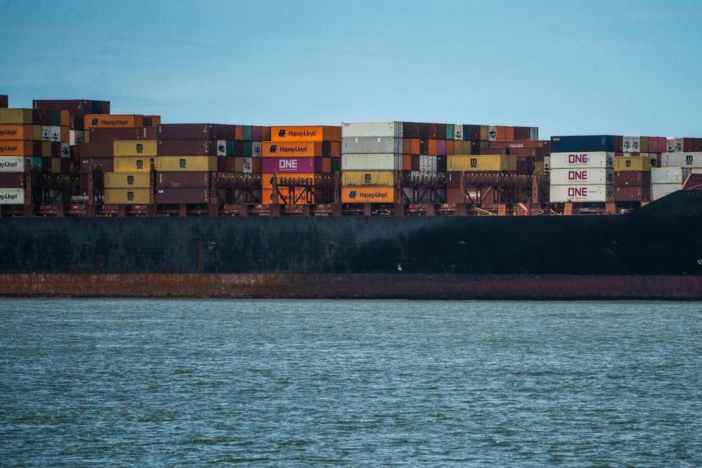 A large container ship is docked in the water